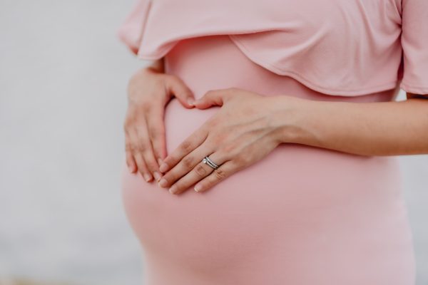 une femme enceinte tient son ventre avant un test de paternité