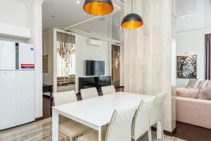 Une salle à manger contemporaine avec des chaises élégantes et des luminaires suspendus, créant une ambiance chic.