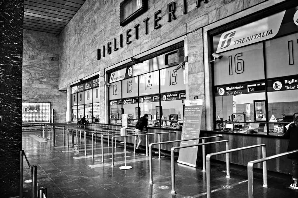 Salle de billetterie avec guichets numérotés et personnes en file d'attente Salle de billetterie avec guichets numérotés et personnes en file d'attente