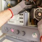 Technicien réglant avec précision un système de chauffage lors d'une installation de pompe à chaleur à Toulouse