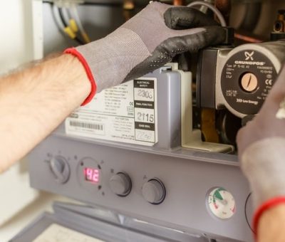 Technicien réglant avec précision un système de chauffage lors d'une installation de pompe à chaleur à Toulouse
