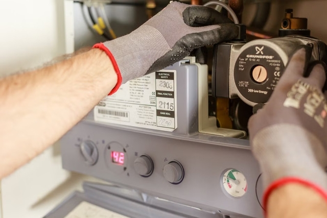 Technicien réglant avec précision un système de chauffage lors d'une installation de pompe à chaleur à Toulouse
