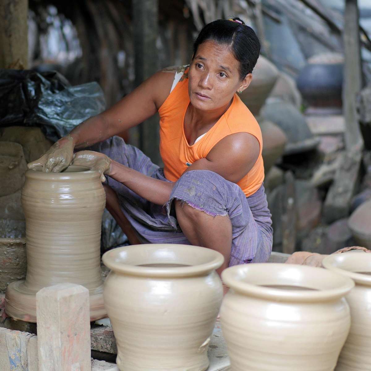 Artisan en train de modeler de la terre cuite dans un environnement de travail traditionnel