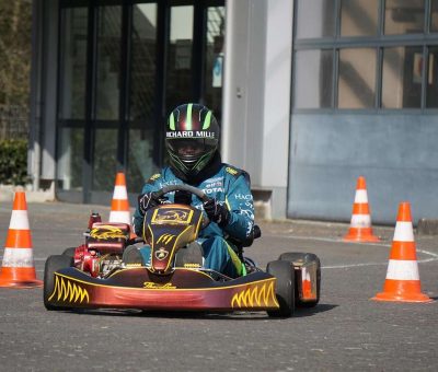 Un conducteur en kart traverse un circuit marqué par des cônes orange