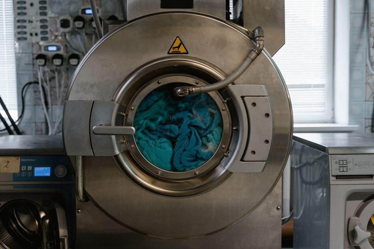 Une combinaison de karting dans un tambour de machine à laver avant nettoyage
